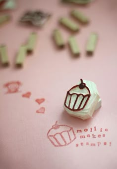 a small cupcake stamp sitting on top of a pink surface