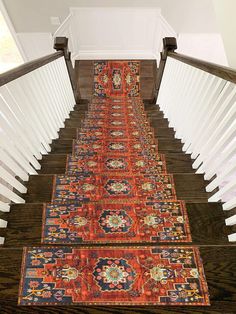 an orange rug is on the bottom of a stair case