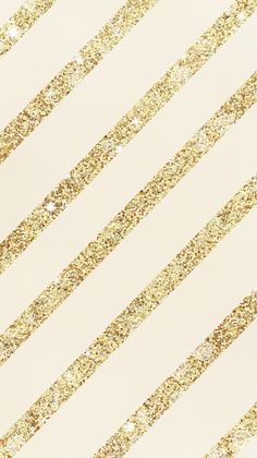 a white and gold striped wallpaper with lots of glitter on the bottom half of it