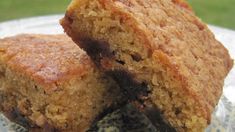 two pieces of cake sitting on top of a white and blue plate with green grass in the background