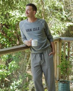 a man standing on a deck holding a cup