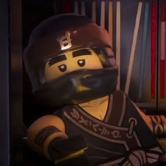 a lego man with a helmet and moustache is sitting in front of bookshelves