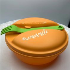 an orange plastic container with a green fork and spoon on it that says, awesome smile