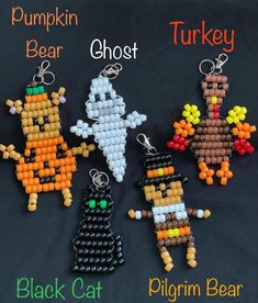 four halloween beaded key chains with pumpkins, ghost, and black cat on them