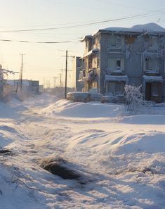 a snow covered street with buildings and power lines in the background