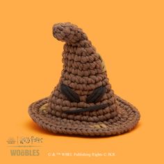 a crocheted wizard hat on an orange background with the words woolies written below it