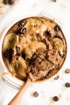 a close up of a bowl of food with chocolate chips and bananas on the side