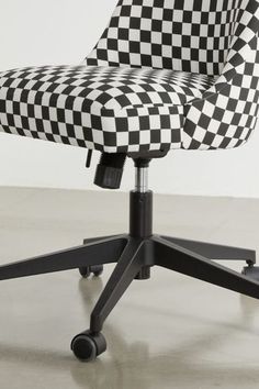 a black and white checkerboard office chair with casteors on wheels, viewed from the front