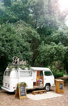 an old van is parked next to a picnic table and chalkboard sign that says photos