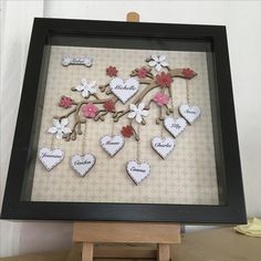 a shadow frame with some hearts and flowers on it, in front of a wall