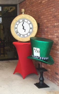 a green hat sitting on top of a red chair in front of a brick building