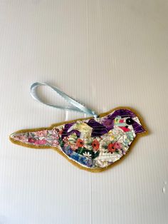 a bird ornament hanging on a white wall