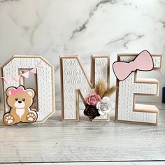 the letters are made out of wood and decorated with teddy bears, flowers, and bows