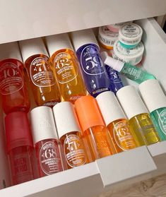 an open drawer filled with lots of different colored bottles