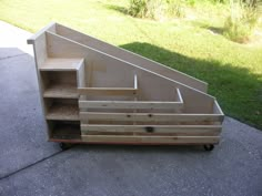 a wooden shelf sitting on top of a cement floor next to a grass covered yard