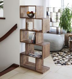 a wooden shelf with books on top of it in a living room next to a window