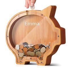 a wooden piggy bank with coins in it and the word emma on top