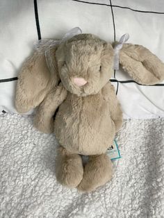 a stuffed animal sitting on top of a bed next to a white blanket and pillow