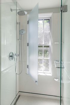 a bathroom with a glass shower door and window in it's corner, next to a white tiled floor