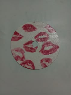 a white disk with red lipstick prints on it