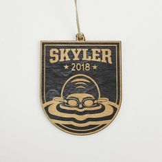 a wooden ornament with the name skyler on it and an image of a man swimming