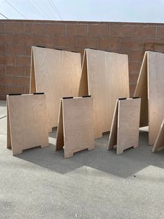 several pieces of plywood are lined up against a brick wall and placed on the ground