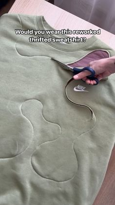 someone is using scissors to cut the fabric on a t - shirt