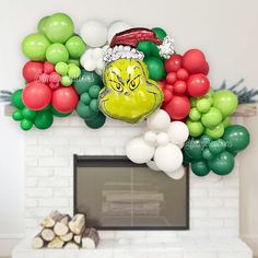 a bunch of balloons that are in front of a fire place with a grin face on it