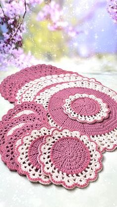 crocheted placemats in pink and white on a table with purple flowers