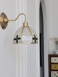 a wall light hanging from the side of a white door