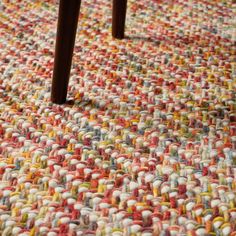 a close up view of a rug with wooden legs