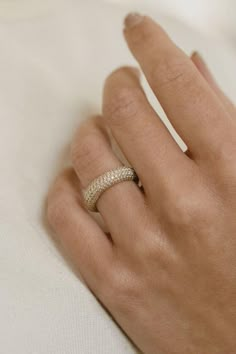 a woman's hand with a gold ring on top of her finger and white background