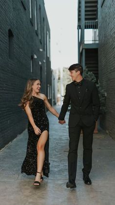 an engaged couple holding hands and walking down the street