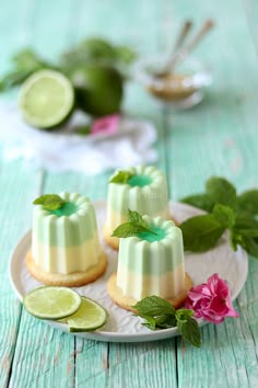 three small desserts on a plate with lime slices and mint garnishes