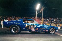 a blue car with the word jungle painted on it's side in front of a crowd