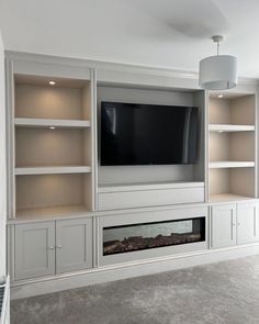 an entertainment center with built in bookshelves and a flat screen tv mounted on the wall