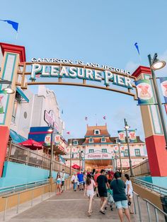 people are walking under the sign at an amusement park