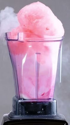 a blender filled with pink liquid and steam coming out of it's top