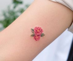 a woman's arm with a flower tattoo on the left side of her arm