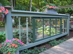 a wooden deck with potted plants and flowers on the railings next to it