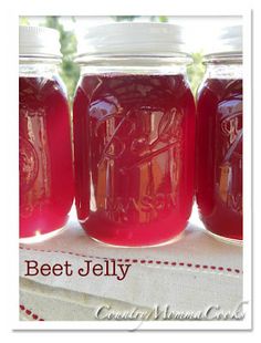 three jars filled with beet jelly sitting on top of a table next to each other