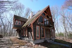 a log cabin in the woods on a sunny day