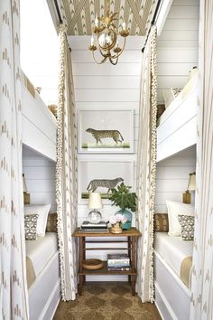 the inside of a bedroom with bunk beds and curtains