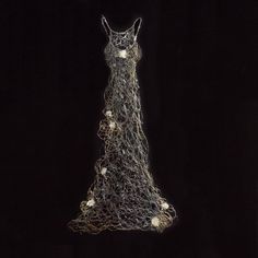 a woman's dress made out of wire and beads