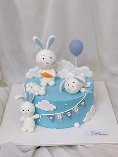 a blue cake with bunnies and rabbits on it