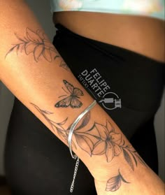 a woman's arm with a butterfly tattoo on it and a chain around the wrist