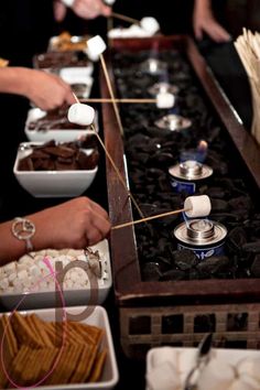 several people are serving themselves food at a buffet