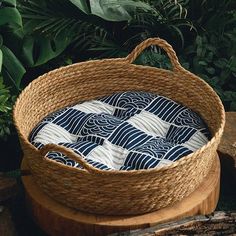 a basket sitting on top of a wooden table in front of some plants and trees