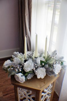 a wooden table topped with white flowers and candles