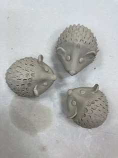 three hedgehog figurines sitting on top of a white table next to each other